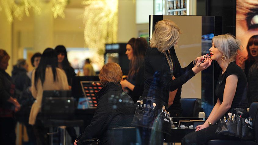 Woman getting makeup in an Estee Lauder shop