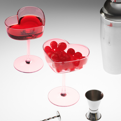 M&S heart coupes holding morello cherries next to cocktail equipment.