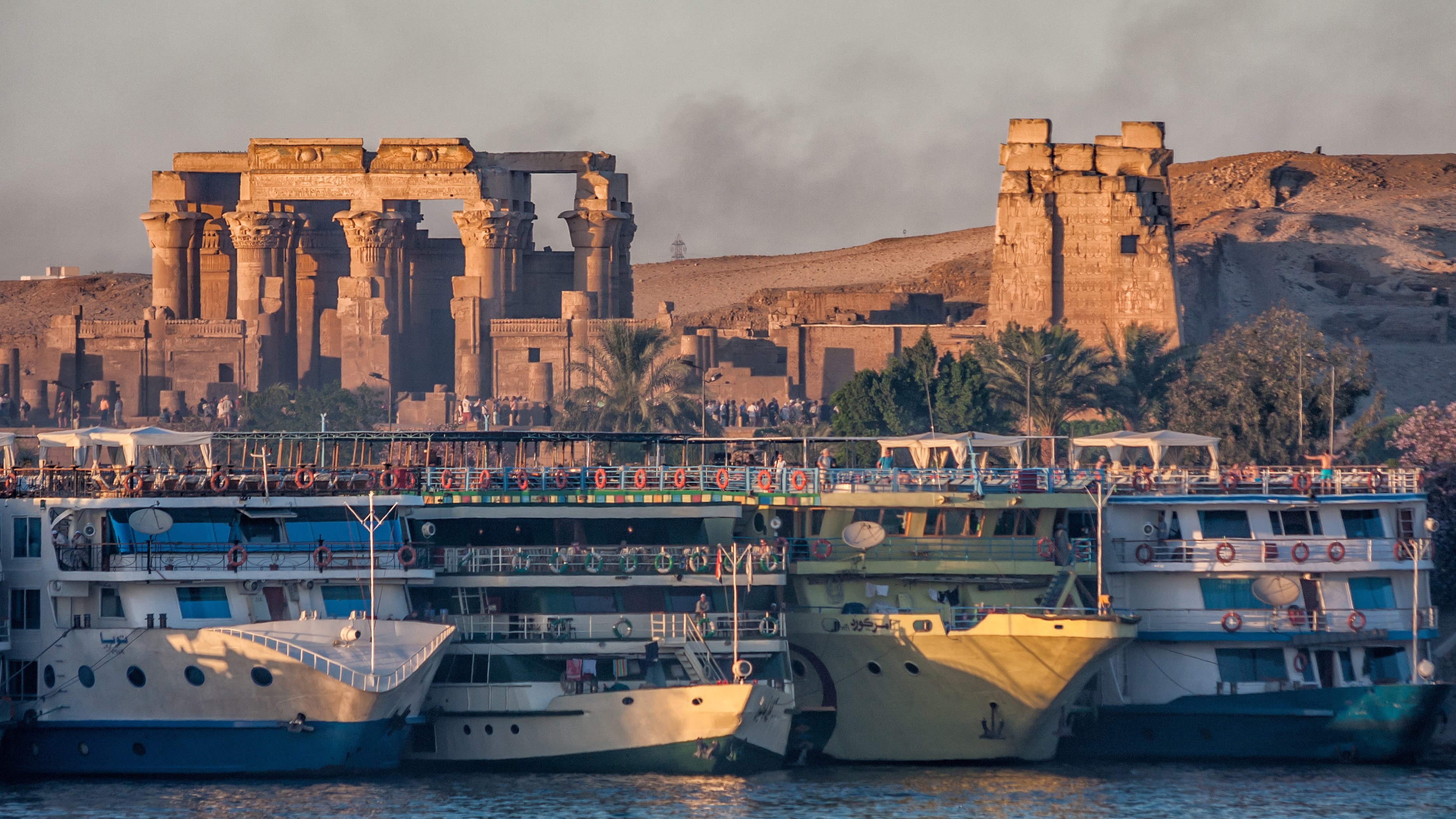 Tourist river cruises parked on the Nile river in front of the temple Kom Ombo. Kom Ombo, Egypt.