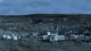 Still from the sci-fi TV series The Expanse. There are several houses and shelters in the distance.