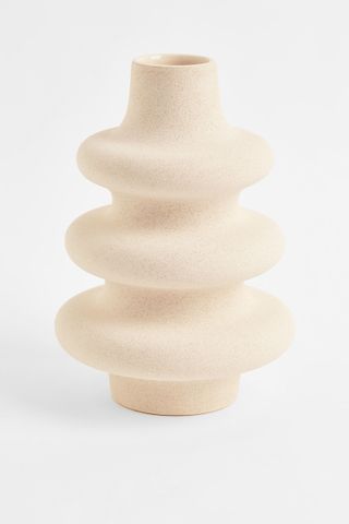 A wavy beige ceramic vase