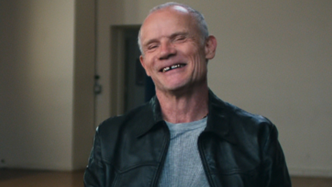 Flea smiling in an interview in The Rise of the Red Hot Chili Peppers: Our Brother, Hillel