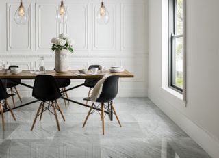 Polished marble floor tiles in modern dining room with black chairs and pendant lighting