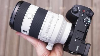 Sony FE 70-200mm F4 Macro G OSS II lens in the hand attached to Sony A6700