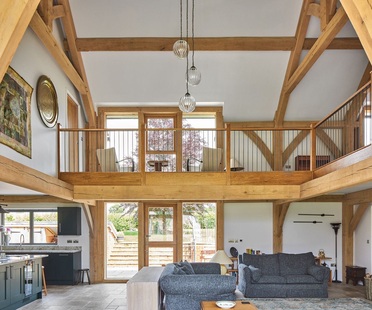 A double height atrium with a landing/mezzanine with lounge chairs.