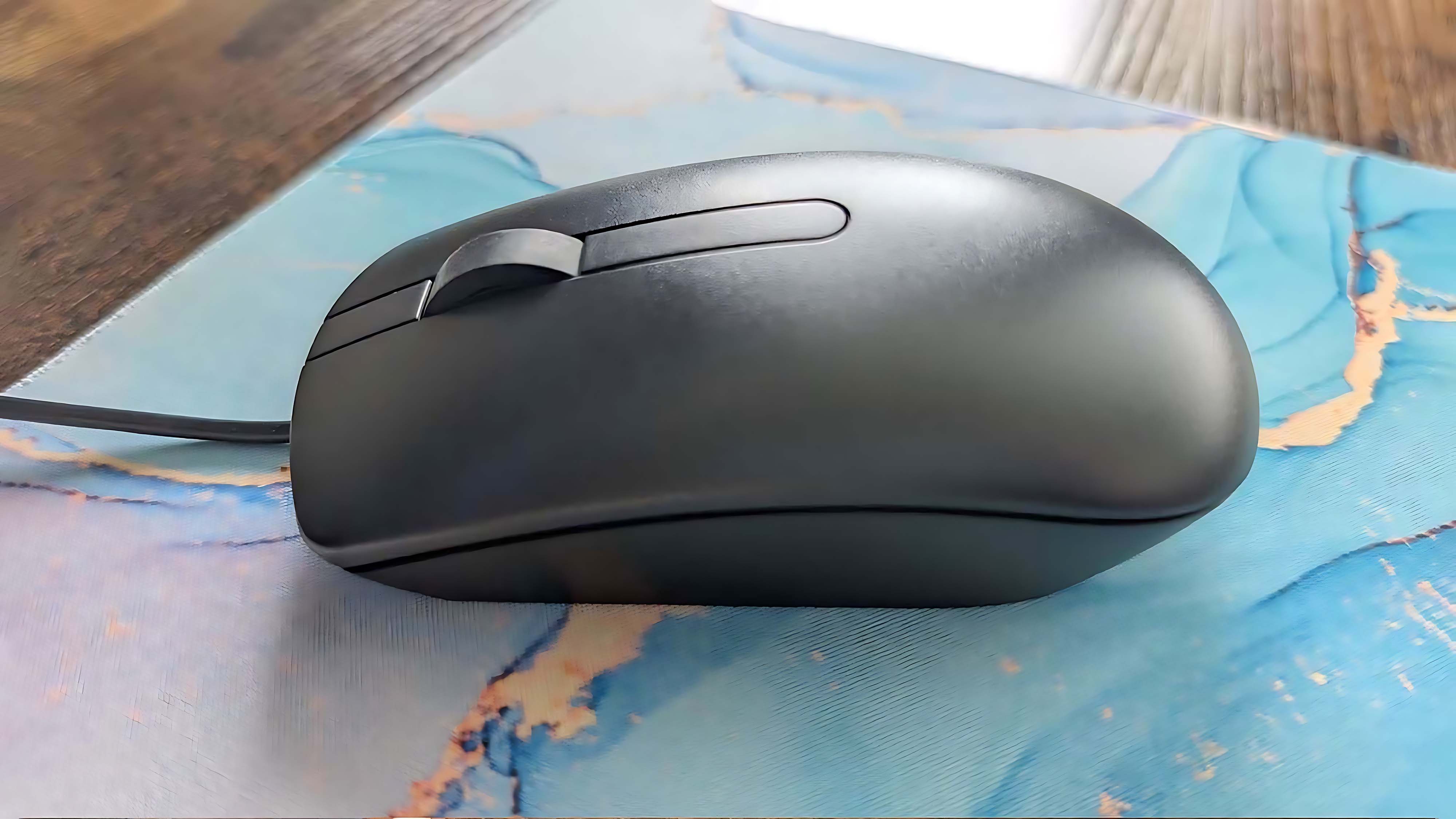 The included wired mouse on a mousepad.