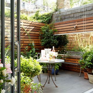 patio area with potted plants and wooden fence