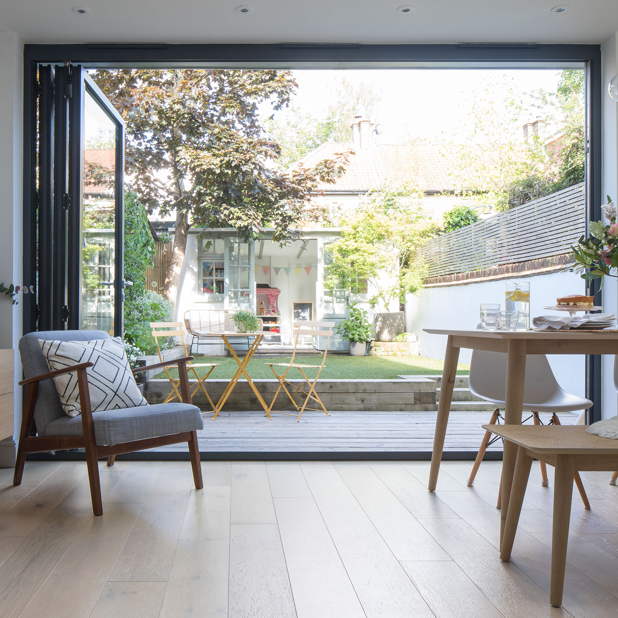 View from extension dining room through bi-fold doors to garden with summerhouse
