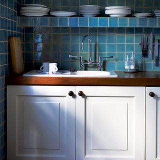 kitchen room with blue tiled walls and kitchen sink