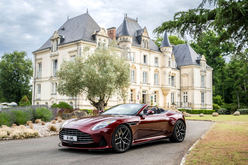 Red Aston Martin car infront of Le Mans Country Club — a 17th century former castle in France