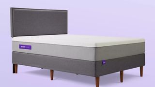 The Purple Hybrid Mattress shown on a lilac background and placed on a dark gray bedframe