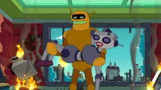 a golden male robot holds a silver female robot in front of a large window, while fires burn around them.