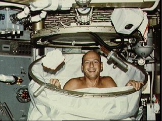 Astronaut Charles Conrad Jr., Skylab 2 commander, smiles for the camera after a hot bath in the shower facility in the crew quarters of the Orbital Workshop of the Skylab 2 space station cluster in Earth orbit. In deploying the shower facility the shower