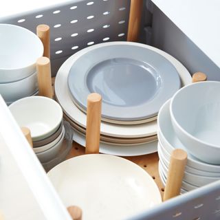 Open drawer with pegs to divide spaces for tableware
