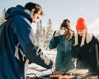 people standing by outdoor BBQ in winter