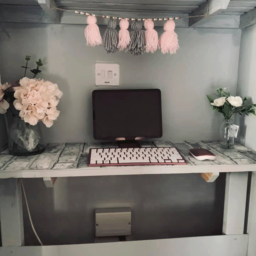 room with grey wall flower vase and computer desk