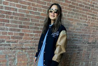 Caroline Maguire wearing a striped button-down and varsity bomber jacket.