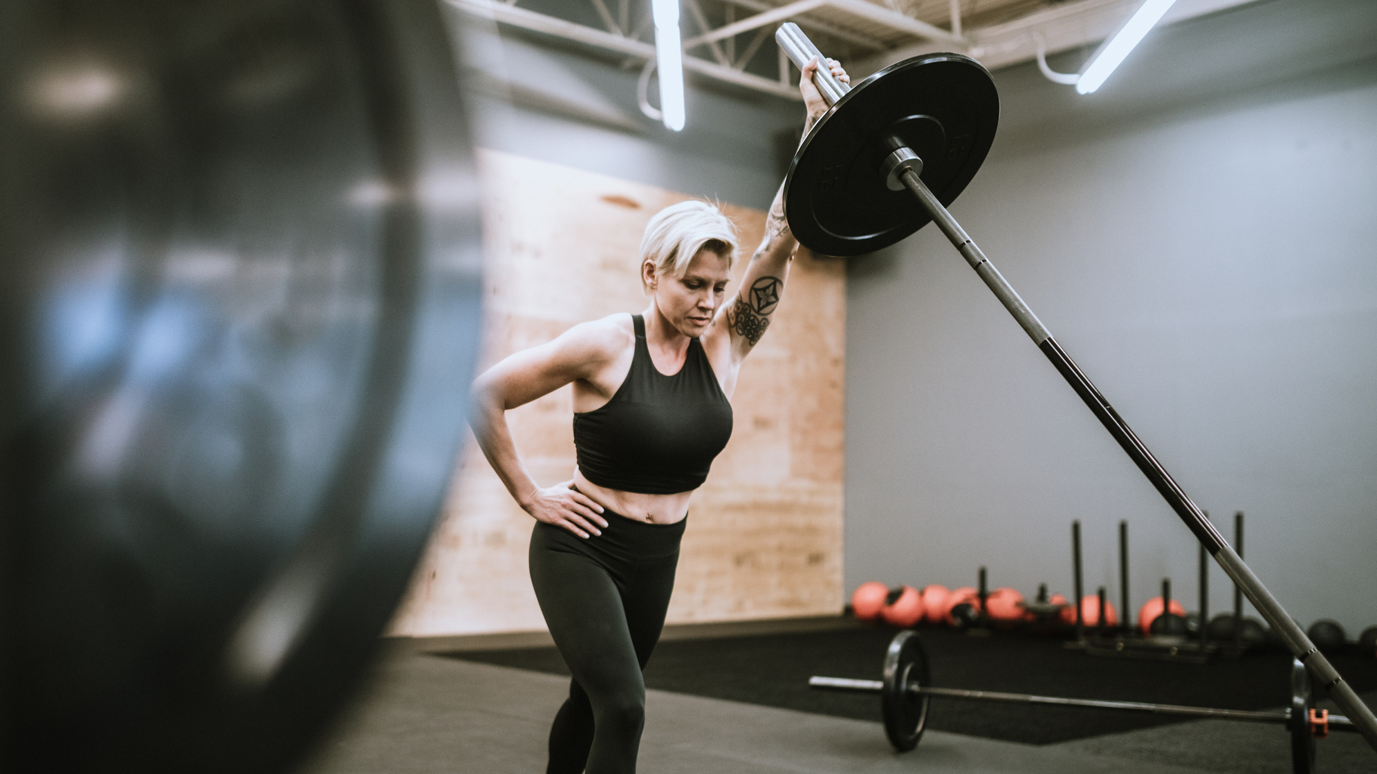 Woman performing landmine press in empty gym