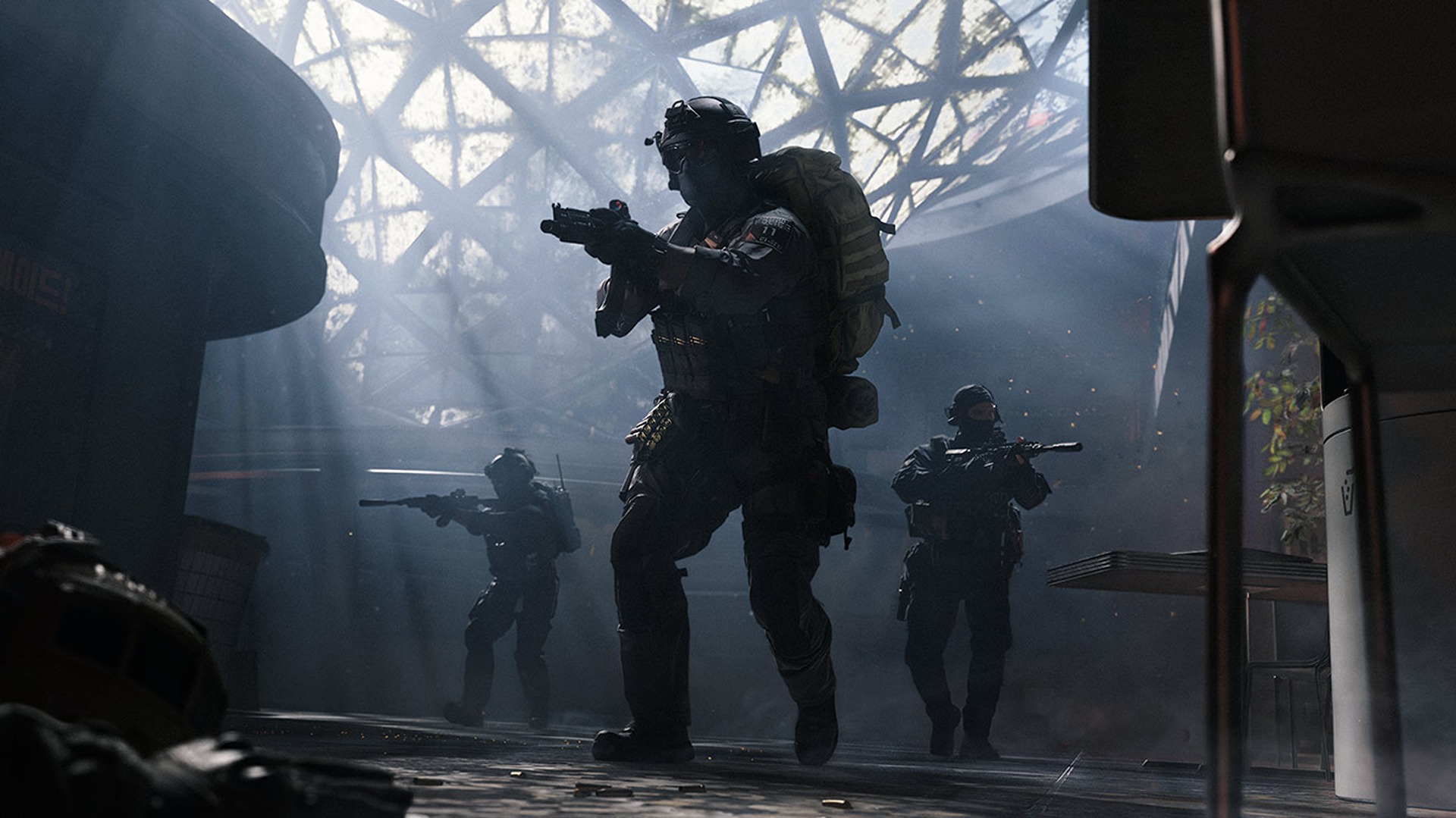 Three soldiers in tactical gear and helmets move through a smoky, industrial indoor space with a large, geometric glass ceiling structure above them.