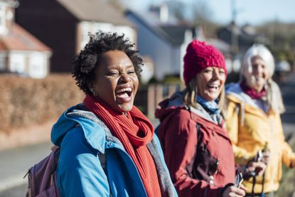 Three women wearing warm clothing in suburban area