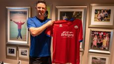 Justin Rose holds an Aldershot Town soccer shirt