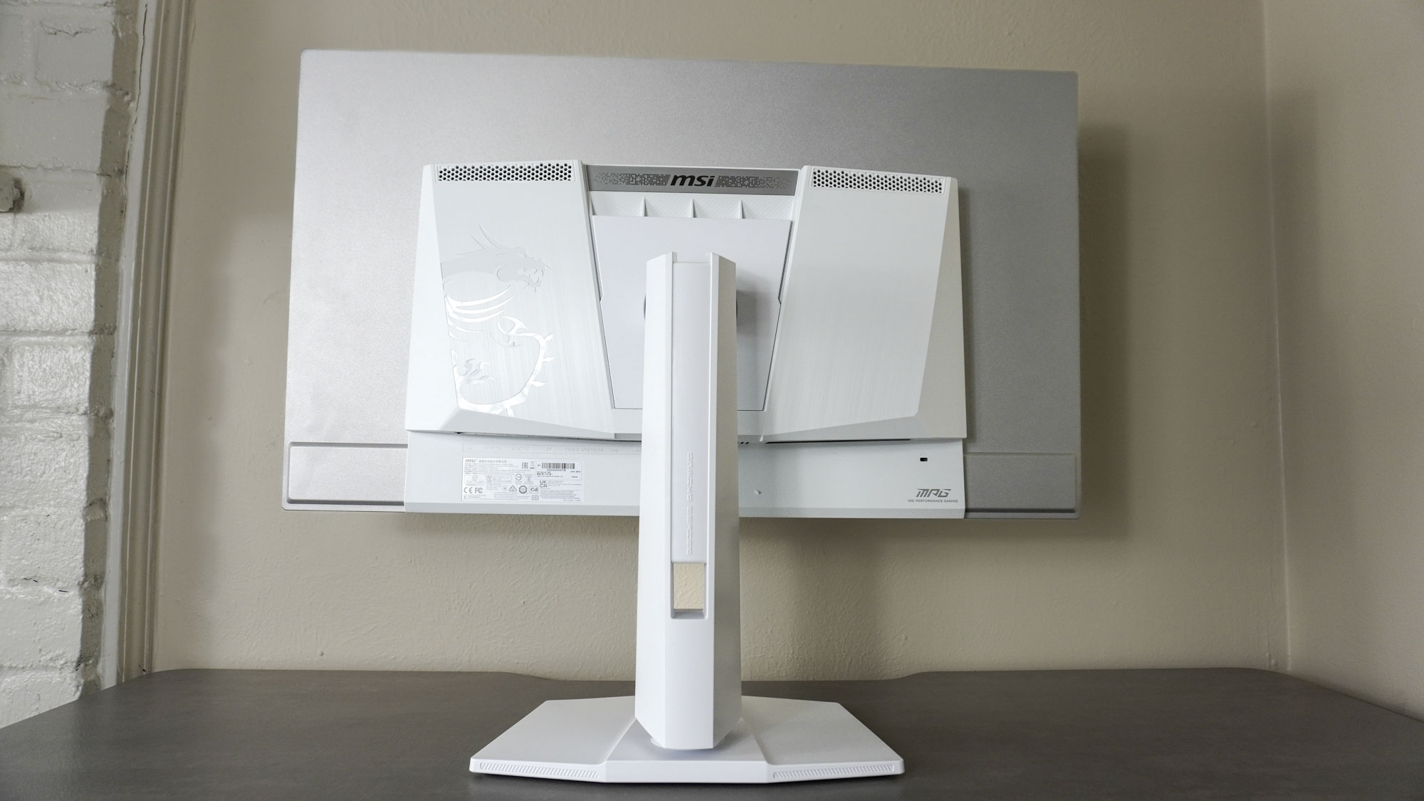 The MSI MPG 321URXW QD-OLED seen from behind on its stand