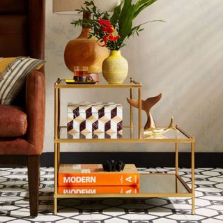 West Elm glass side table with three mirrored levels each wide than the next and edged with gold metal