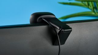 the back of a small, black, oblong-shaped webcam with a universal attachment clip and a logi logo