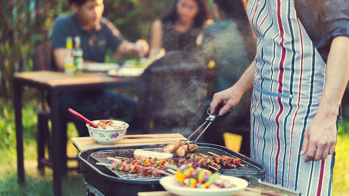 Man grilling food on barbecue outside