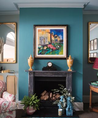 blue living room with marble fireplace and artwork