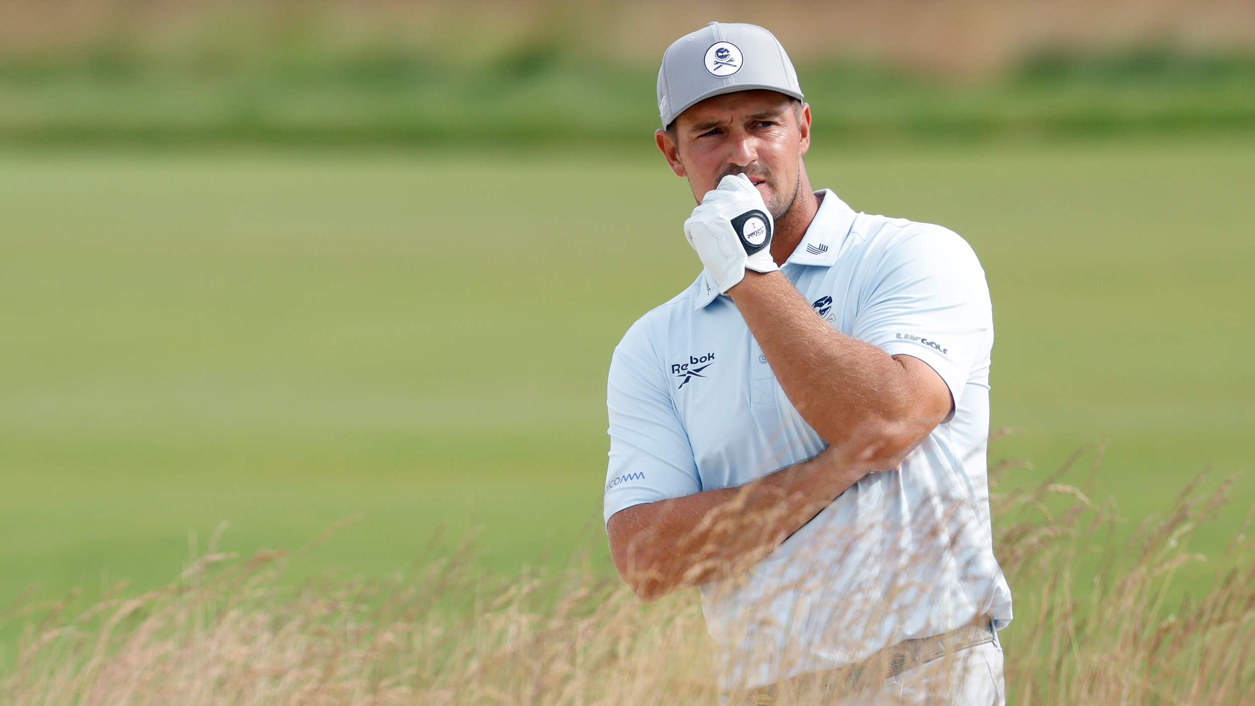 Bryson DeChambeau holds his chin while thinking over a shot at the US Open