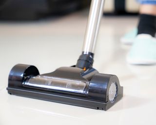 Black vacuum with silver handle cleaning floor
