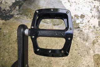 DMR V12 flat pedal attached to a crank arm