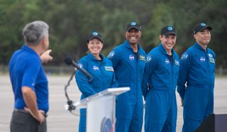 The four astronauts of NASA's Crew-1 mission launching on a SpaceX Crew Dragon spacecraft and Falcon 9 rocket smile after arriving at the Kennedy Space Center in Cape Canaveral, Florida Nov. 8, 2020 for their upcoming launch. KSC director Bob Cabana (left) points to the crew, who are (from left): NASA astronauts Shannon Walker, Victor Glover, Mike Hopkins and Japan Aerospace Exploration Agency astronaut Soichi Noguchi.