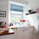 sink area with red flower vase and white tiles