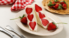 Japanese strawberry sando on a plate next to a bowl of strawberries.