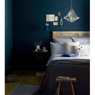 bedroom with dark blue wall wooden bed and chrome yellow wooden flooring