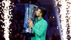 Novak Djokovic kisses the trophy after winning the 2023 Nitto ATP Finals 