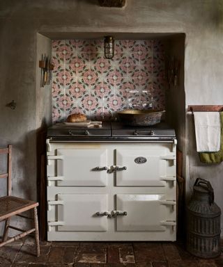 An aga in a traditional kitchen with a tile mural kitchen backsplash