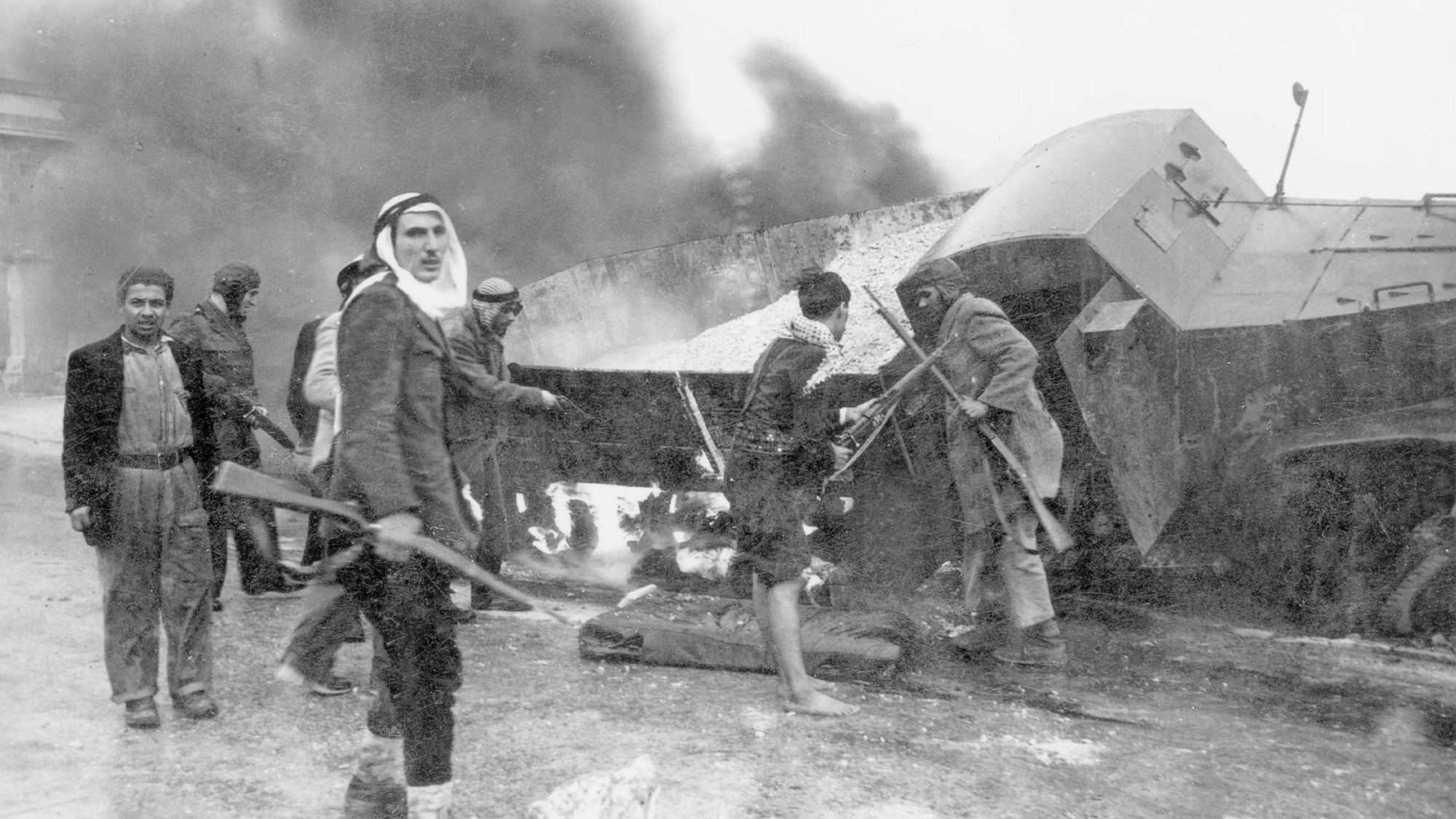 Arab militia next to a burning truck