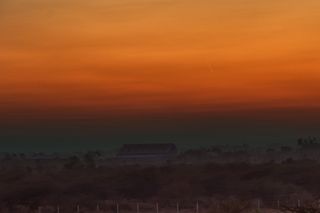 a fuzzy yellow streak in an orange sunset sky