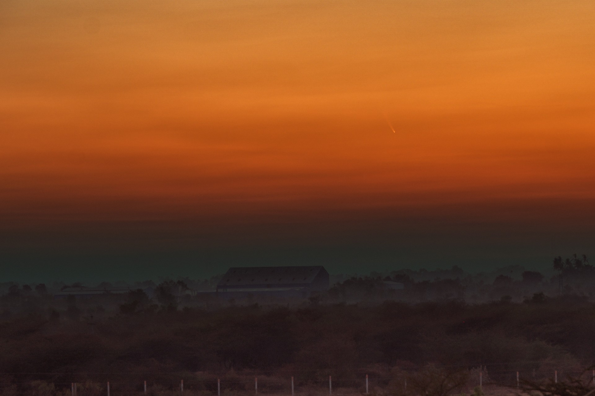 a fuzzy yellow streak in an orange sunset sky