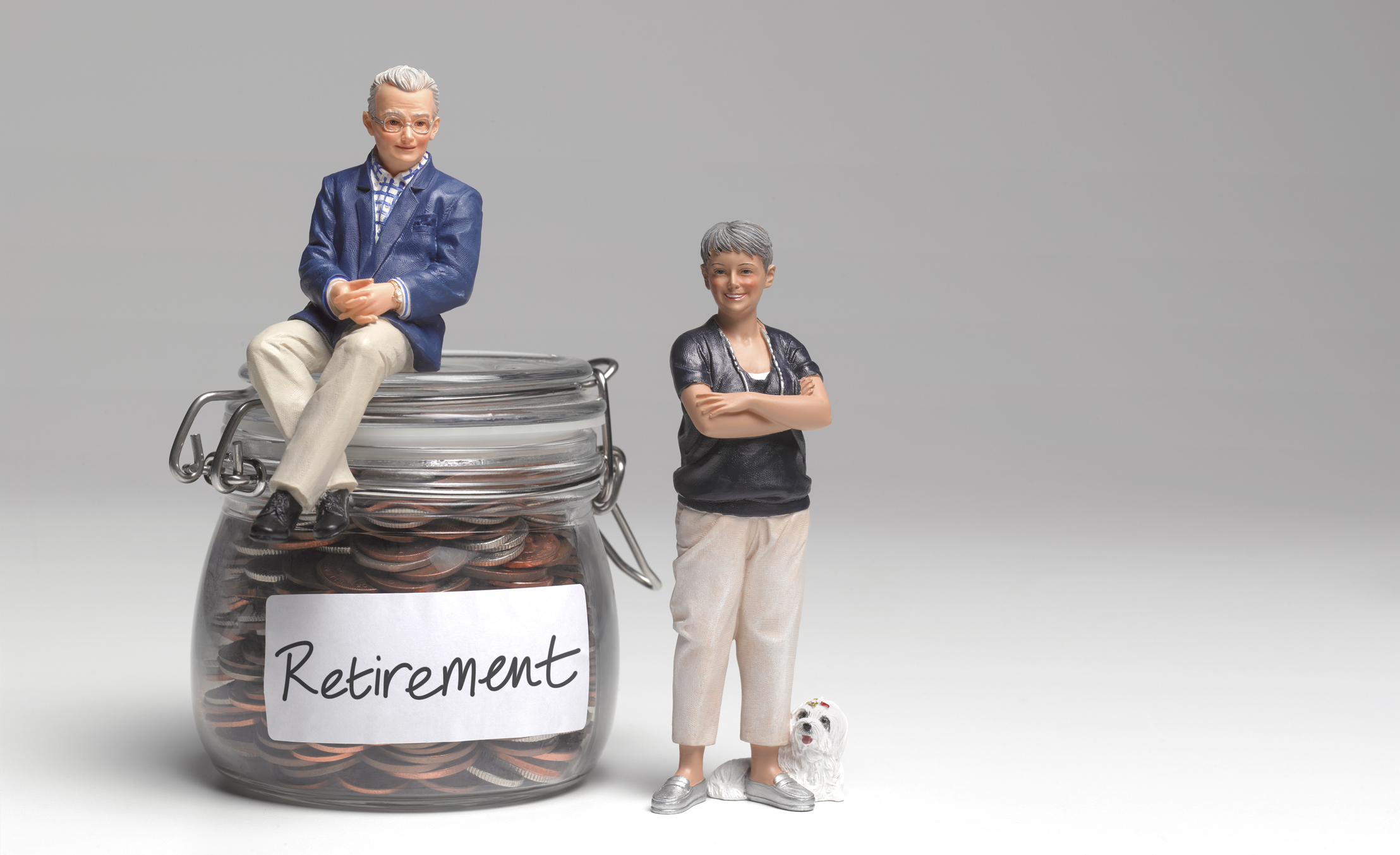 Figures of pension savers sitting on a retirement savings jar of coins