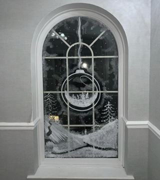 christmas window painted with a bauble illustration and snowy scene