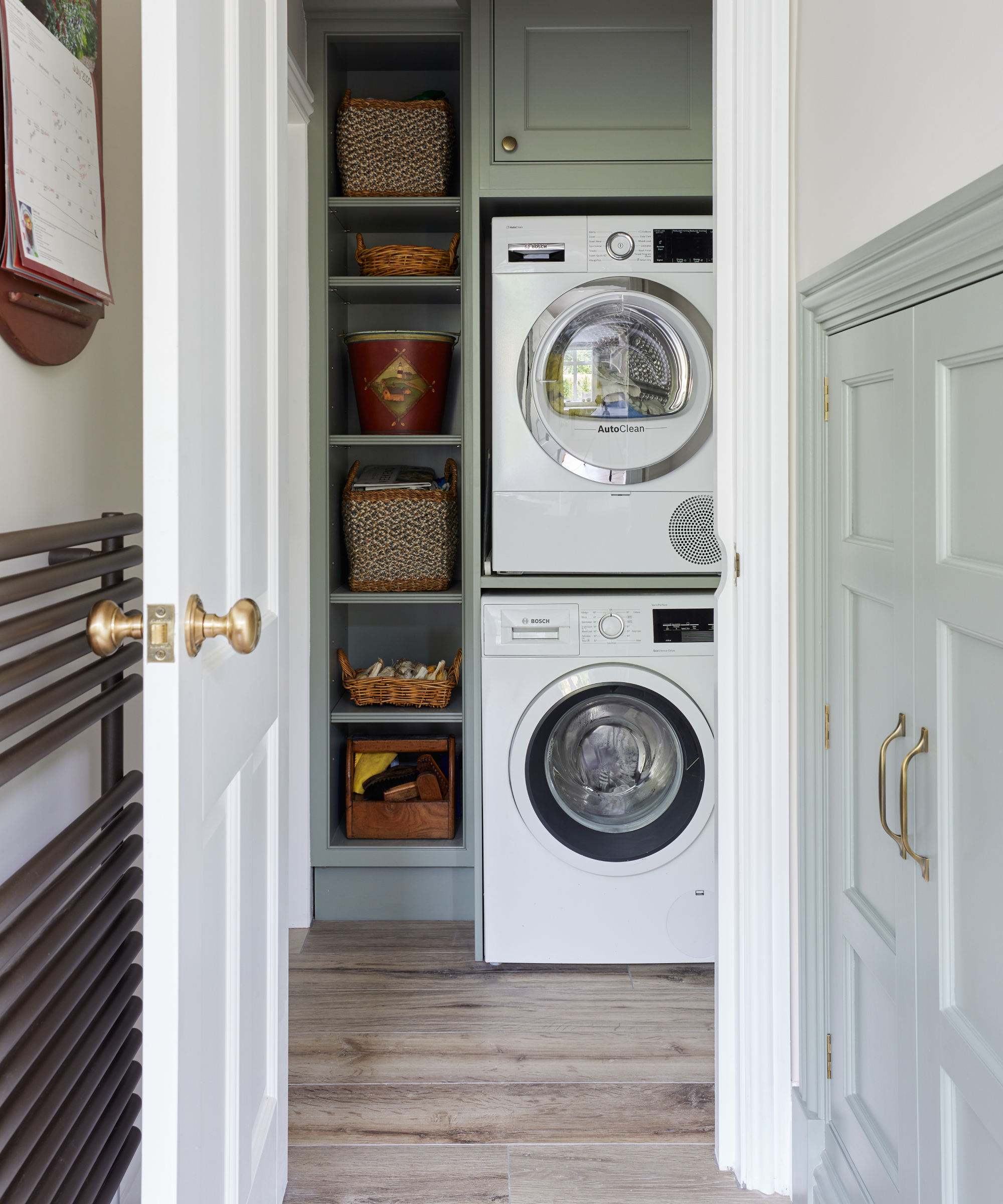 Utility area in hallway with stacked washing machine and tumble dryer