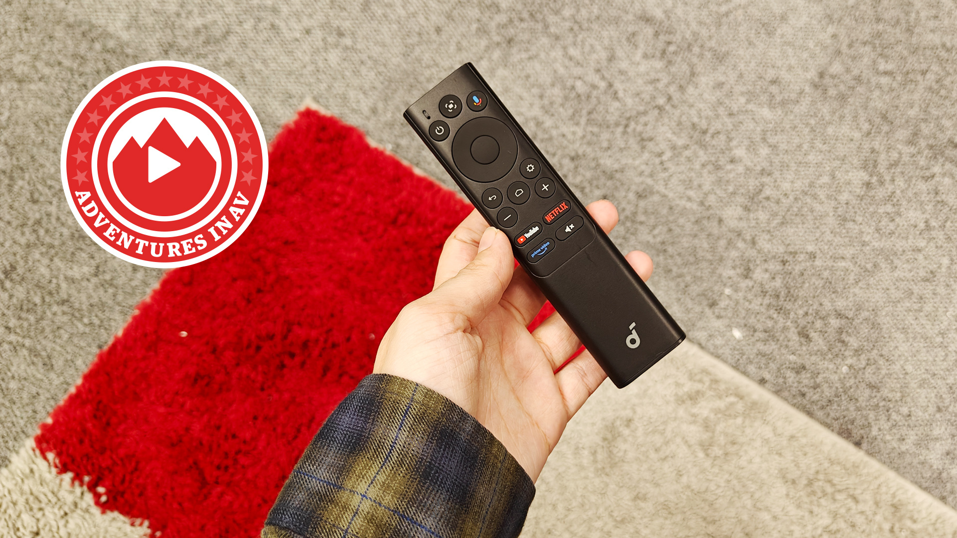 A remote control being held in a hand.