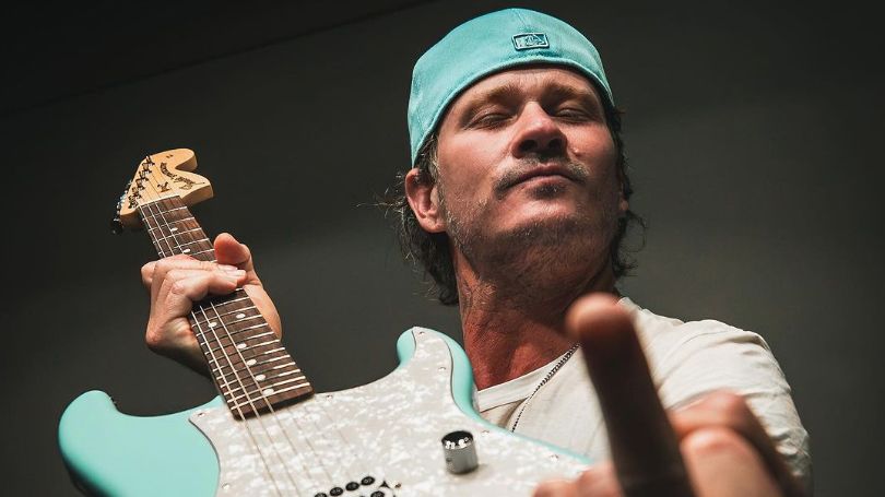 Tom DeLonge holding a signature Fender Strat 