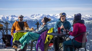 Group of friends enjoying apres-ski at top of Whistler mountain