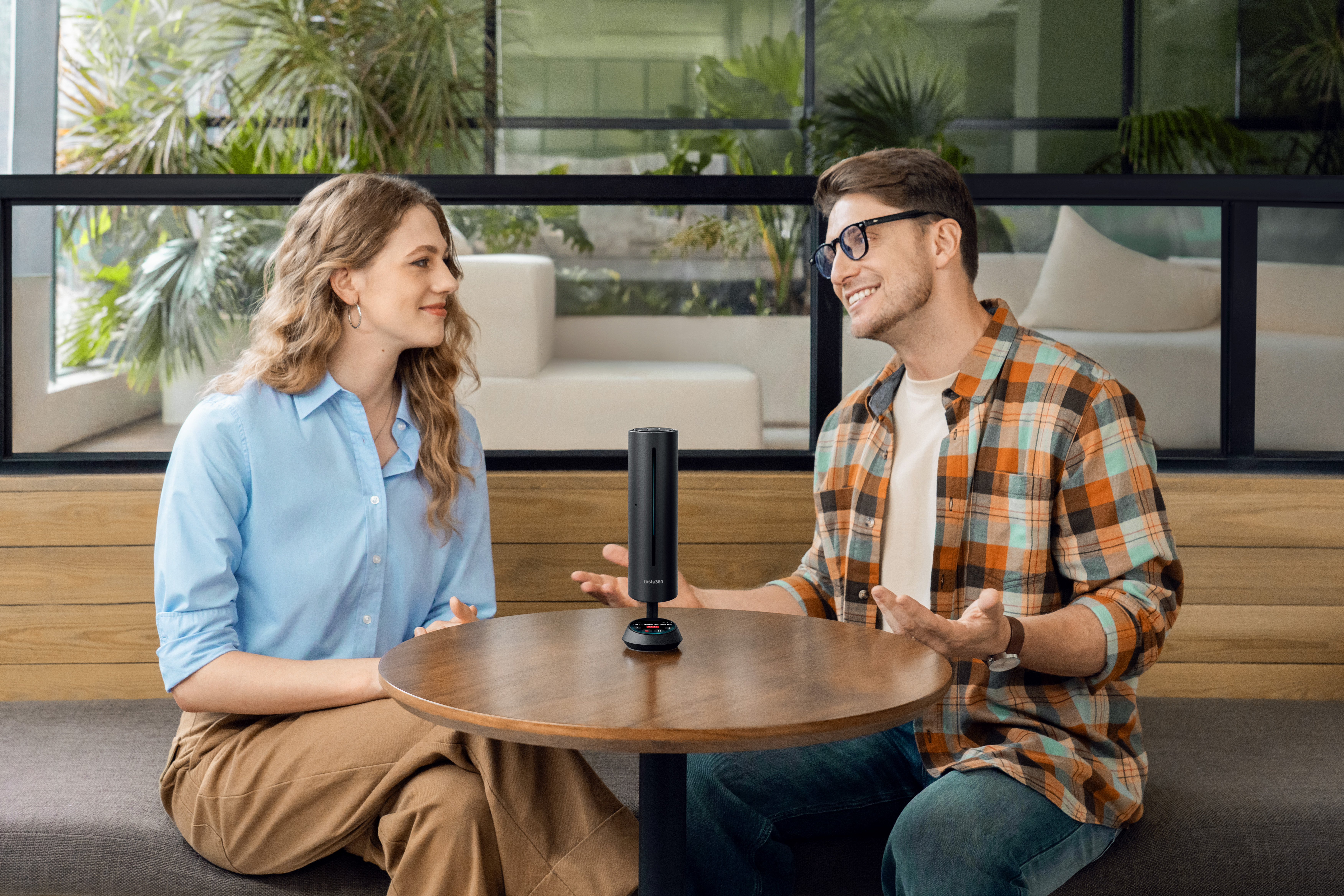 Insta360 Wave device on a table between two people having a casual chat