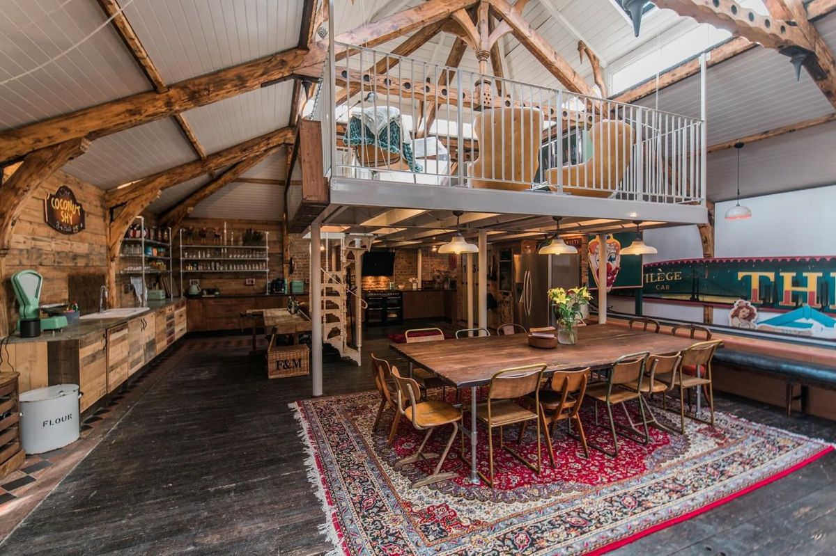 A kitchen-diner with a wooden dining table and a kitchen island all with oak tops